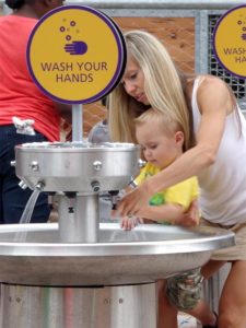 A mom helps her son wash his hands at KidZooU